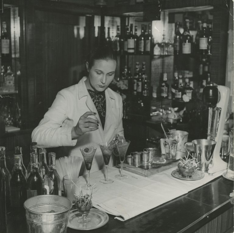 Baarimestari Mirjam Hyttinen tekee juomasekoitusta baaritiskin takana.