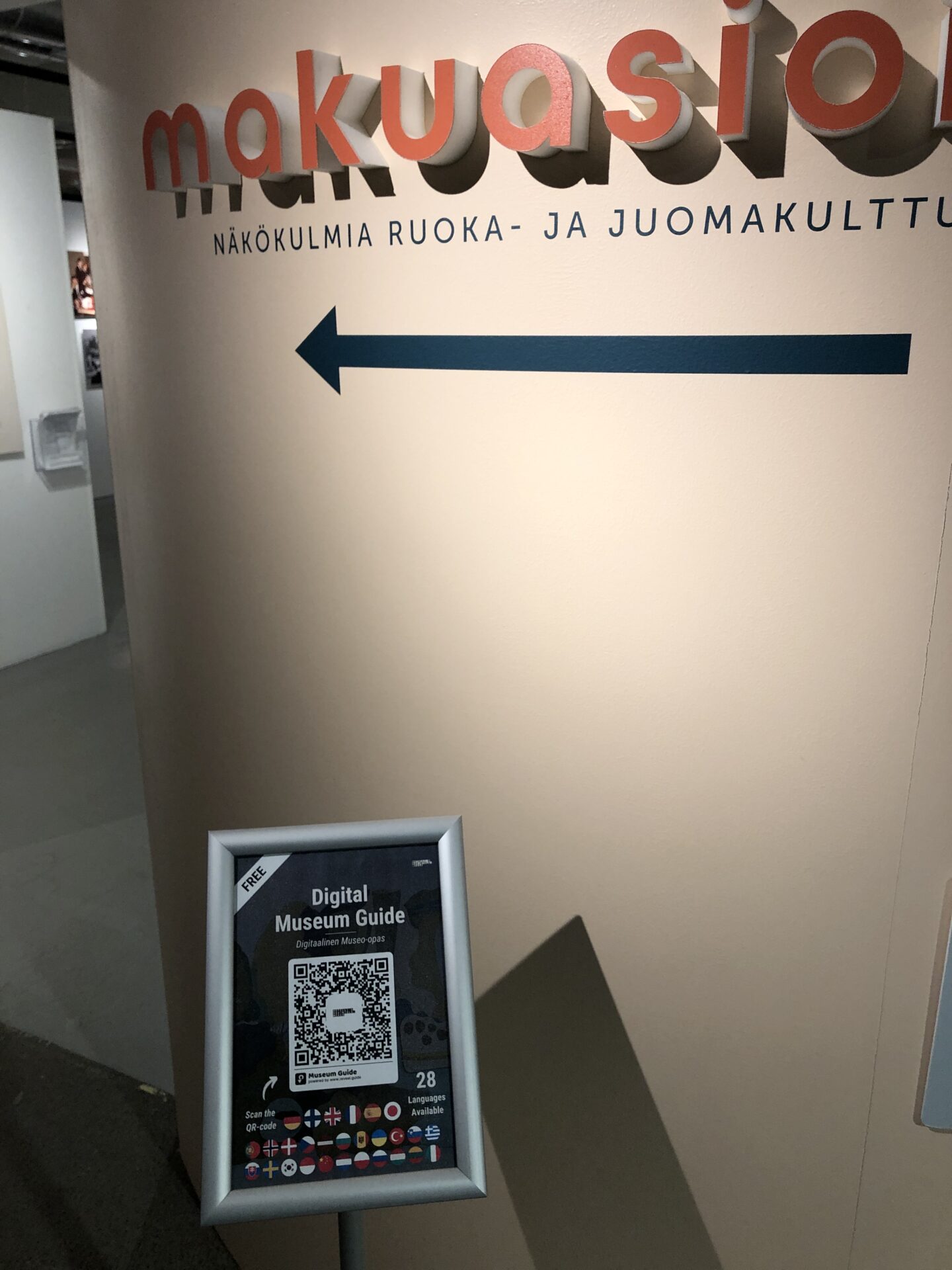A sign about the museum's digital museum guide in front of an exhibition header.