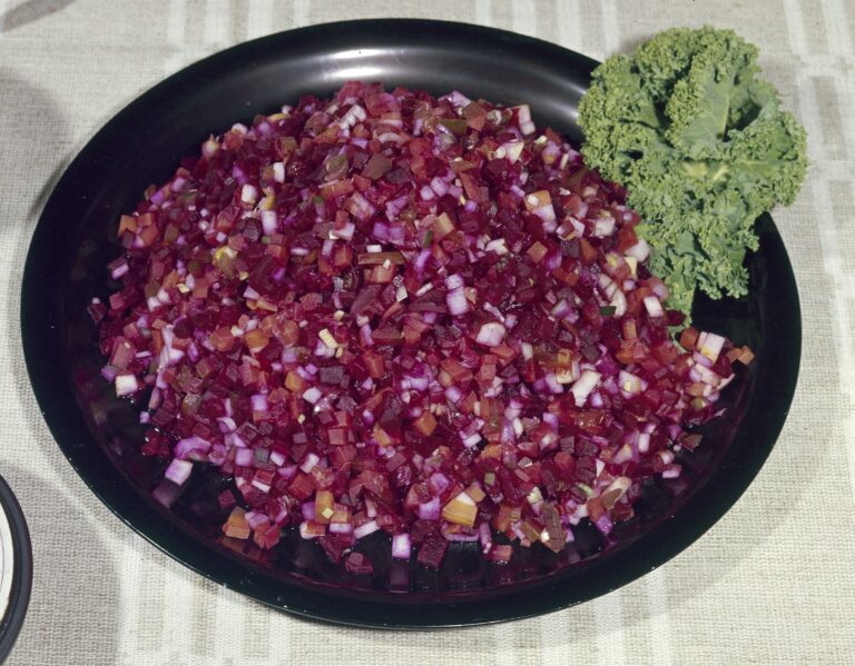 Musta lautanen, jolla hienoksi pilkottua rosollia. Laidalla koristeena vihreä lehtikaalin lehti.